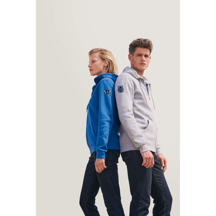 Sudadera azul con capucha y logo de mariposa en la manga para mujer y sudadera gris con capucha y logo de búho en la manga para hombre, ambas combinadas con vaqueros oscuros.
