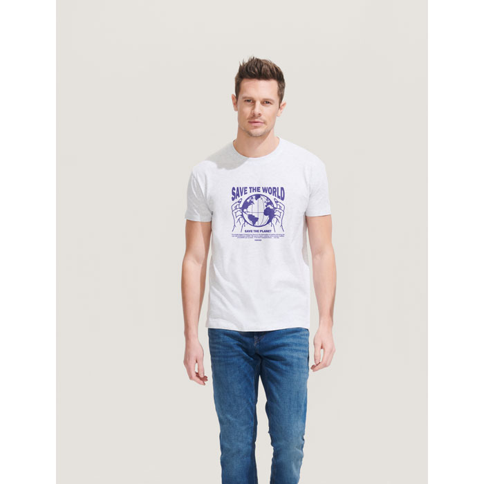 Hombre con camiseta blanca de algodón con estampado azul "Save the World" y vaqueros azules.