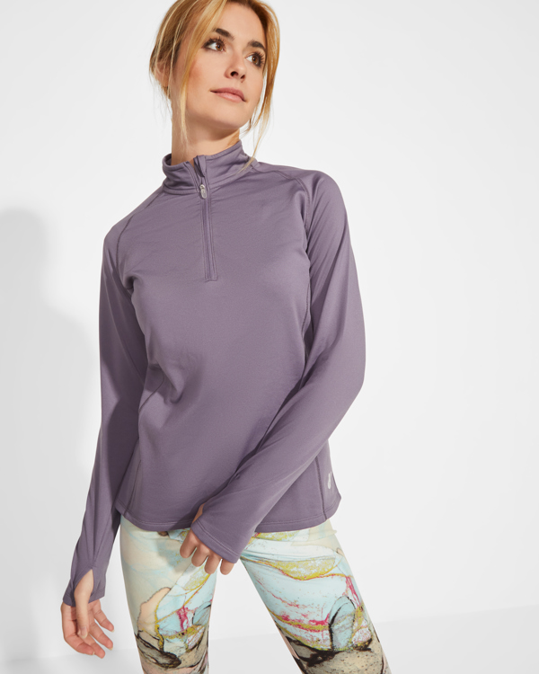 Camiseta deportiva de manga larga morada con cremallera corta y detalle de ojal en las mangas.