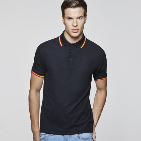 Polo negro de manga corta con detalles naranjas en cuello y puños, combinado con vaqueros claros.