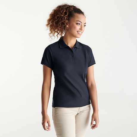 Mujer con polo azul marino de manga corta y pantalones beige.