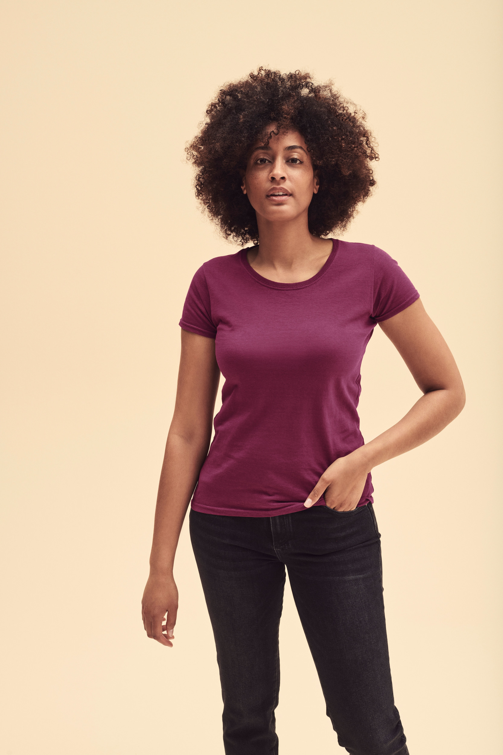 Mujer con camiseta básica de algodón color burdeos y pantalones vaqueros negros.
